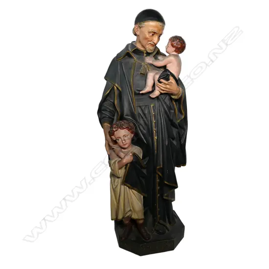 An early 20thC French terracotta religious figure group of St Vincent de Paul with two children