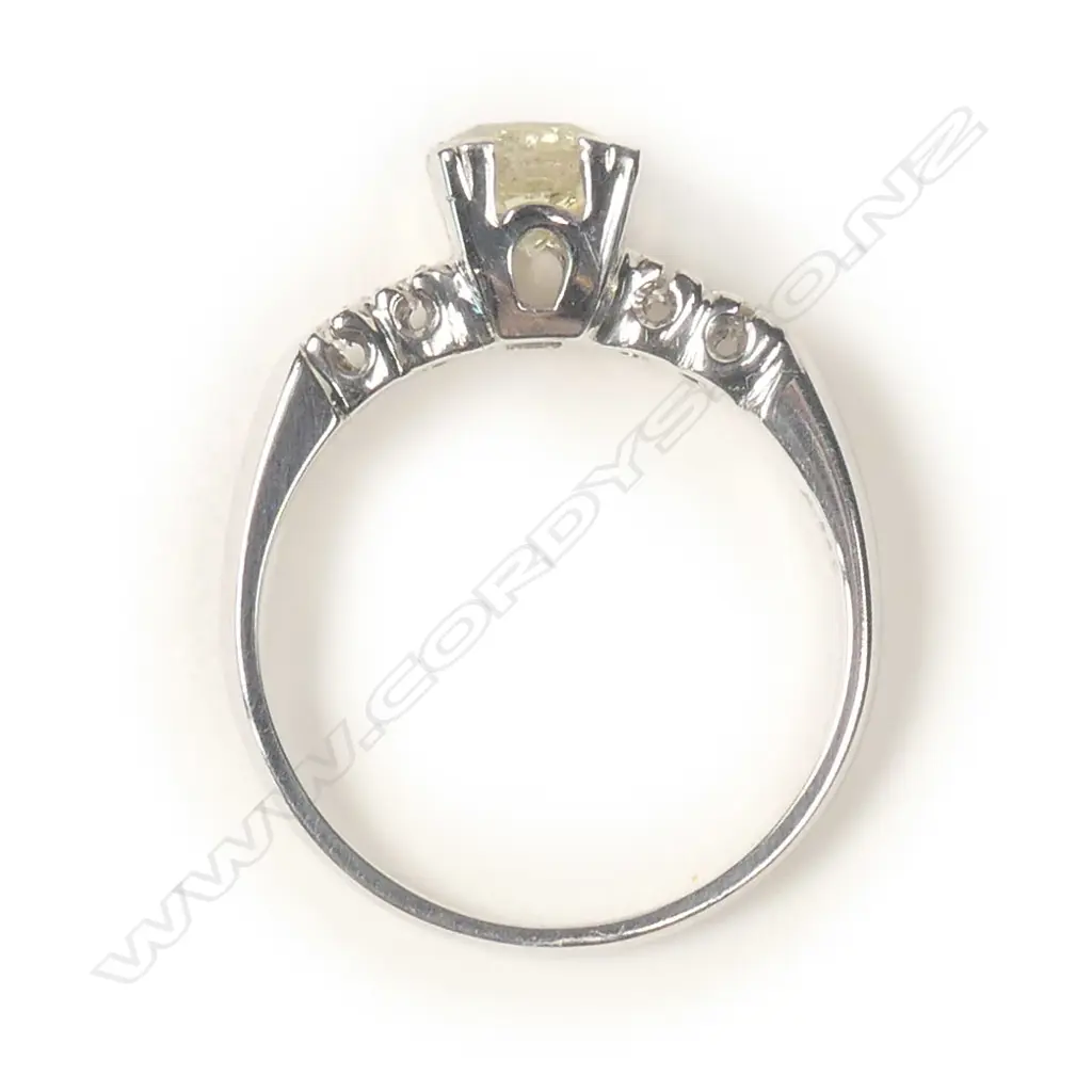 A 14ct white gold and diamond ring, a 0.74ct round brilliant cut diamond claw set with two brilliant cut diamonds to each shoulder, TDW 0.82ct. Valuation available. Image 1++