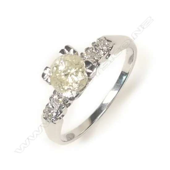 A 14ct white gold and diamond ring, a 0.74ct round brilliant cut diamond claw set with two brilliant cut diamonds to each shoulder, TDW 0.82ct. Valuation available.