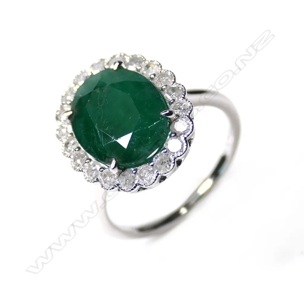 A 14ct white gold emerald and diamond halo ring Image 1++