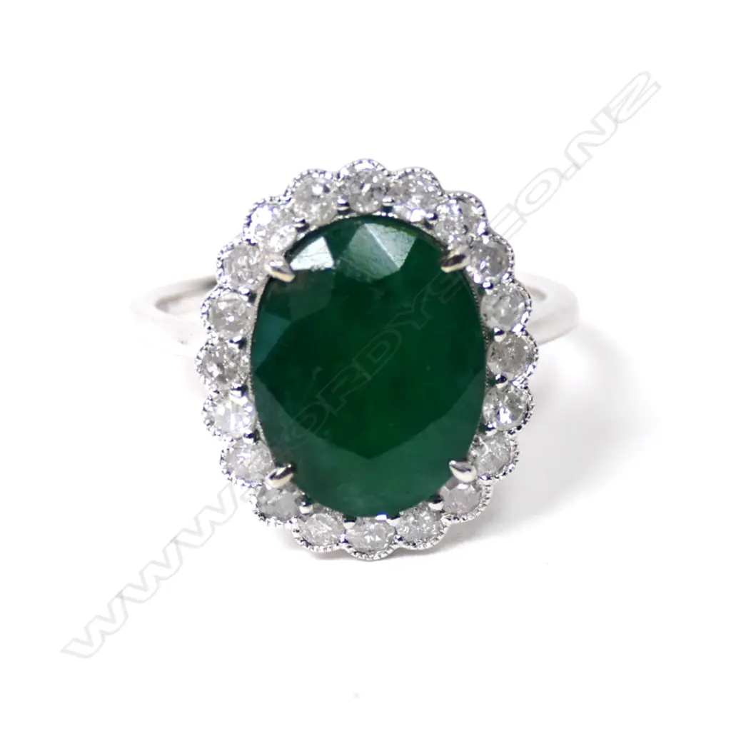 A 14ct white gold emerald and diamond halo ring Image 1++