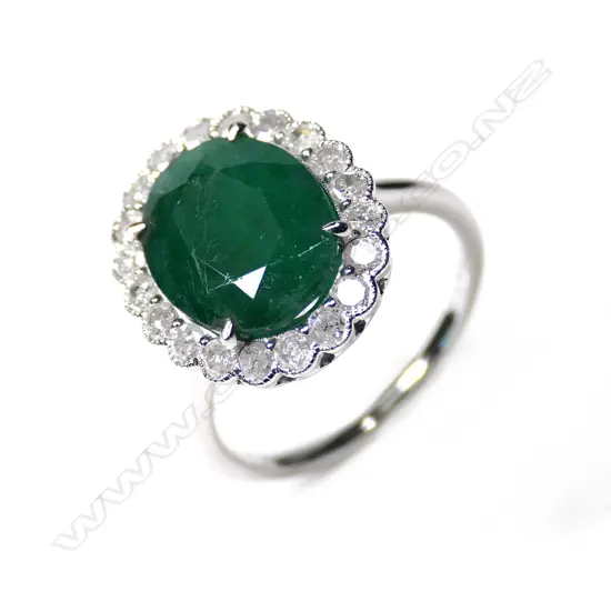 A 14ct white gold emerald and diamond halo ring