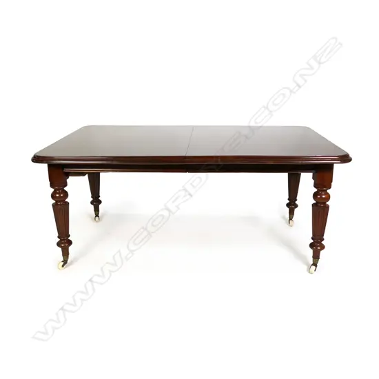 A Victorian mahogany banquet table with four leaves extends to seat twelve