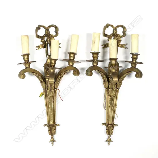 A pair of gilt brass three-light wall sconces