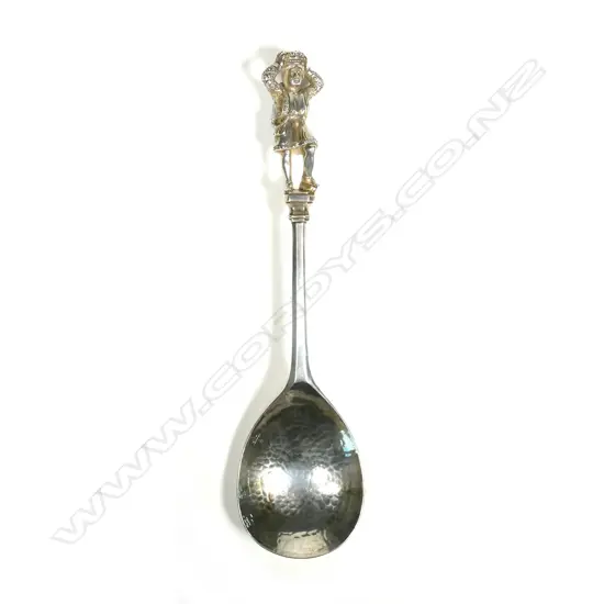 A serving spoon with figured finial