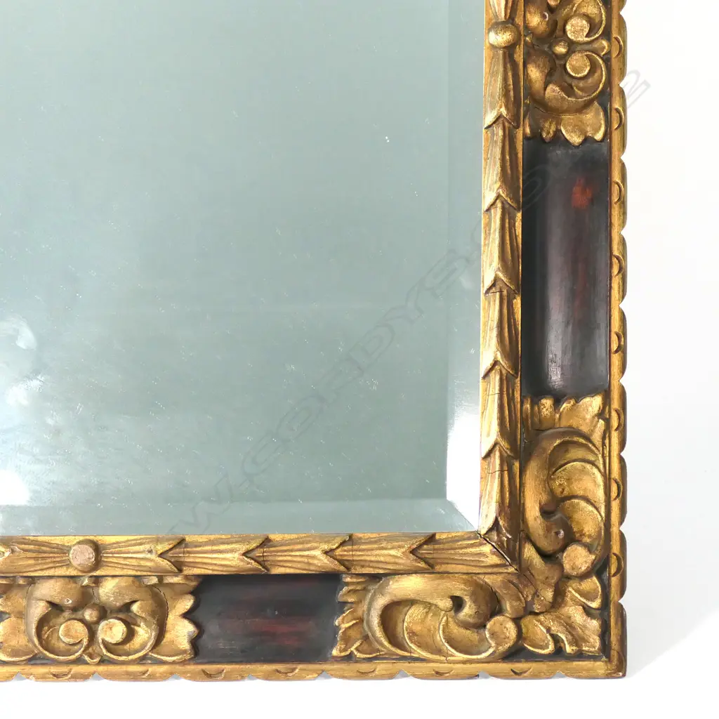 A parcel gilt and ebonized framed bevelled mirror Image 1++