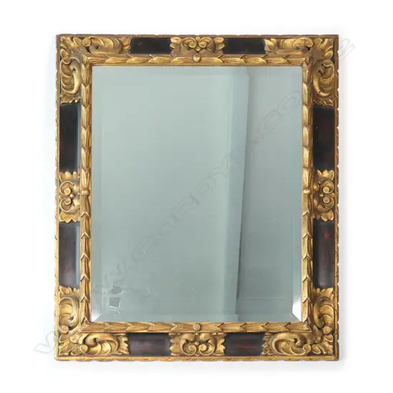 A parcel gilt and ebonized framed bevelled mirror