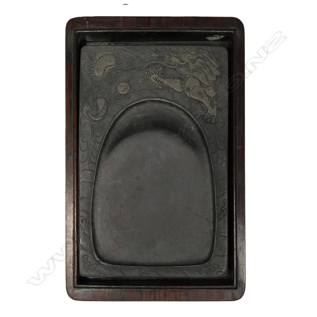 A vintage Oriental hardwood boxed inkstone, rosewood box with inlaid calligraphy to the lid, the inkstone with shaped well framed by a dragon in relief. 245 x 145 x 60mm. Image 1++