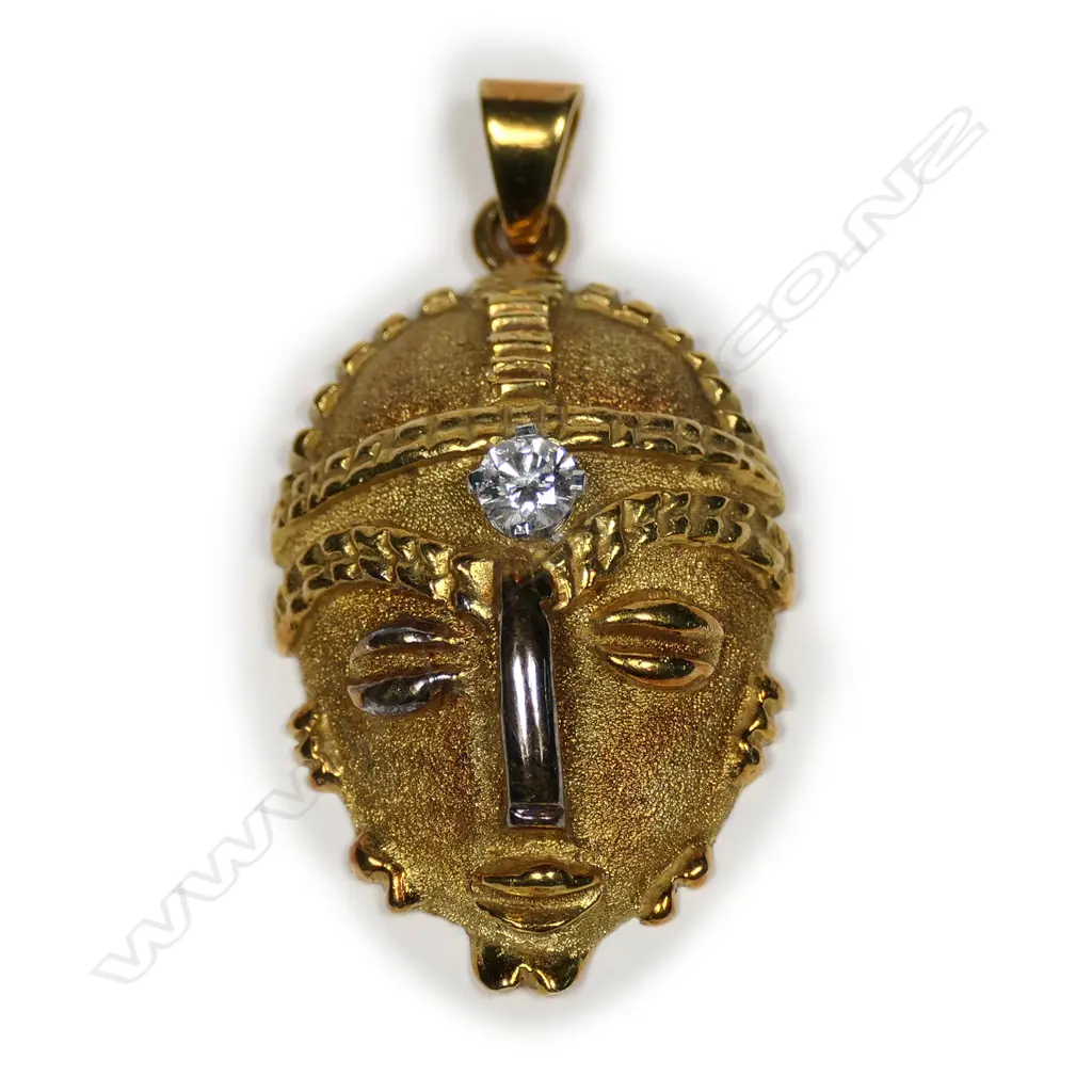 A heavy 18ct yellow gold and diamond set African mask pendant Image 1++