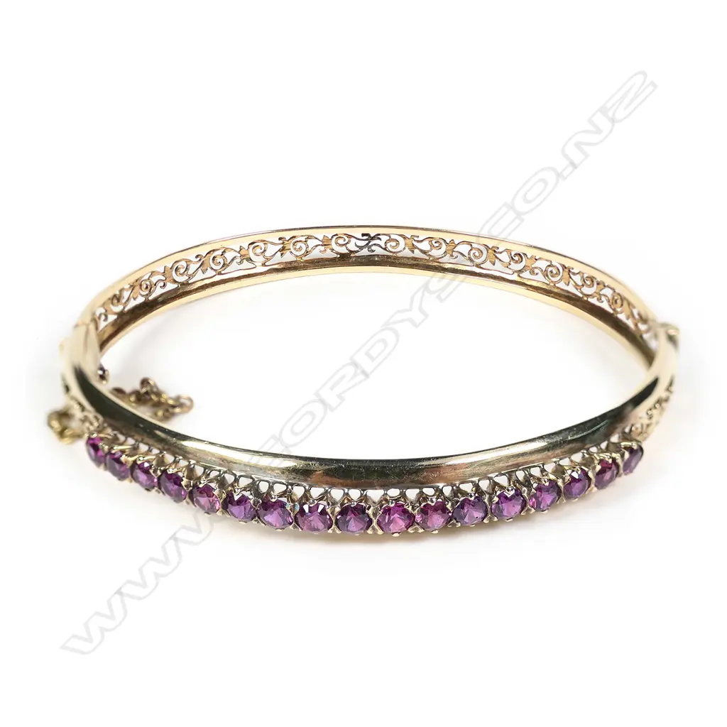 An early 20thC 18ct yellow gold and 17 Garnets set hinged bangle Image 1++