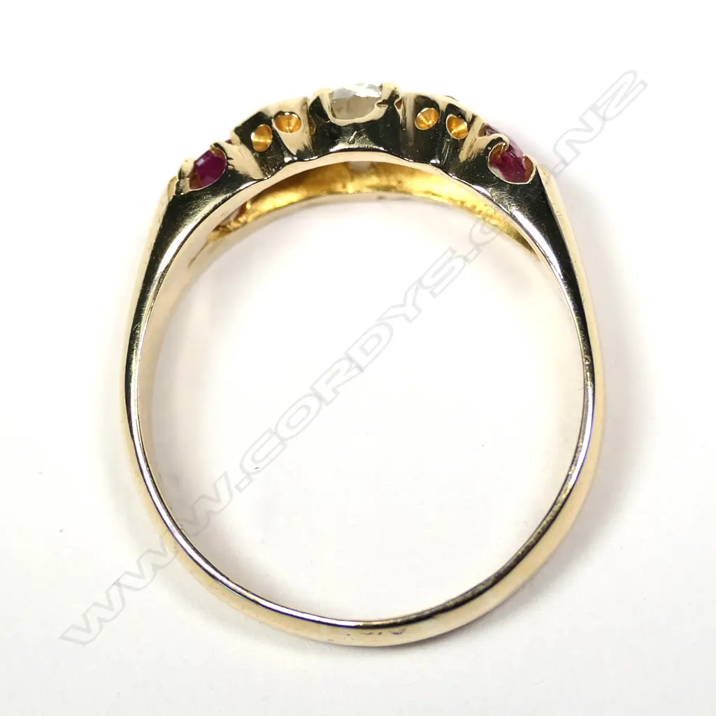 An late 19thC 18ct gold ruby and diamond ring, the central large diamond flanked by diamond enhancers and two facet cut rubies. One chipped. Image 1++