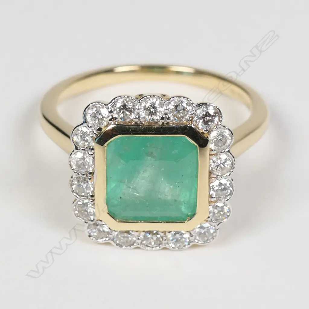 A 14ct yellow gold Columbian emerald and diamond halo ring Image 1++