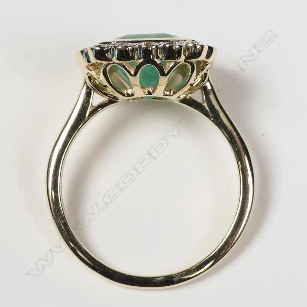 A 14ct yellow gold Columbian emerald and diamond halo ring Image 1++