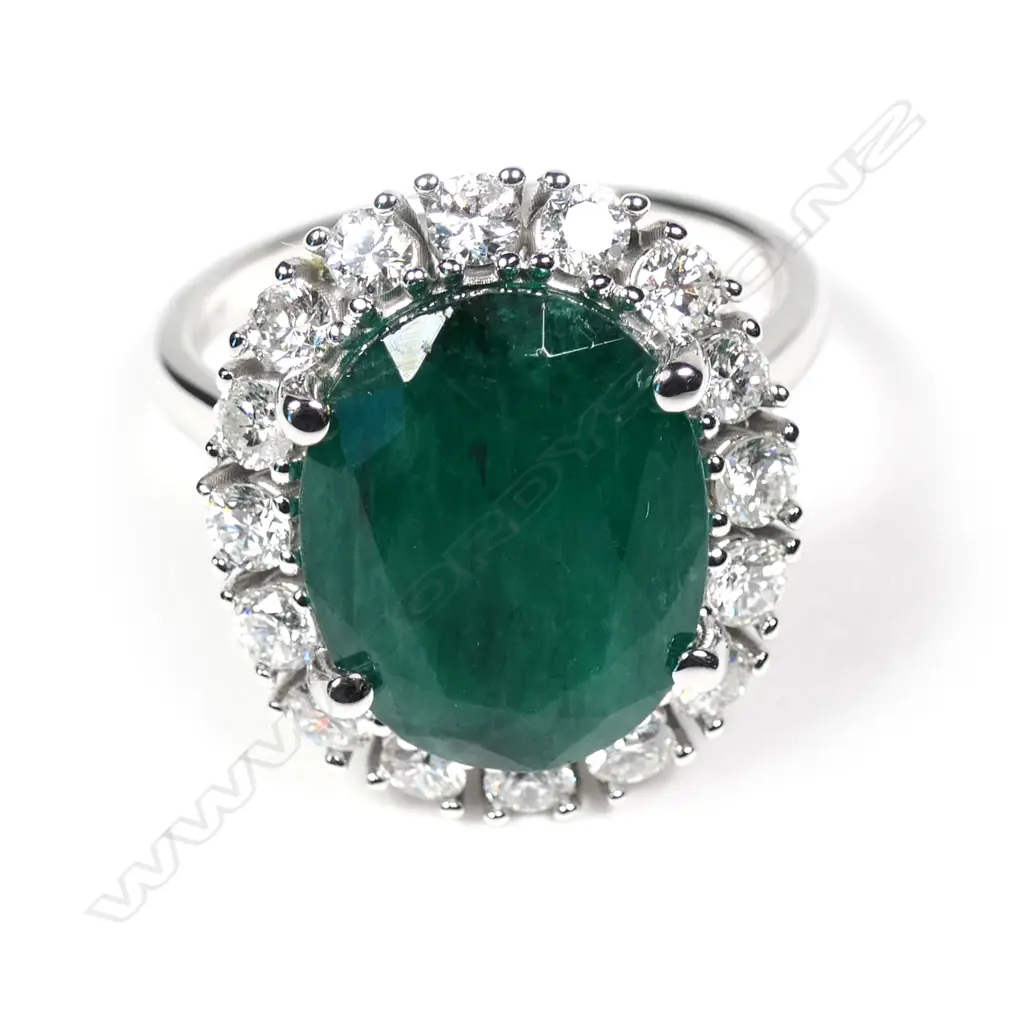 A 14ct white gold Zambian emerald and diamond halo ring Image 1++