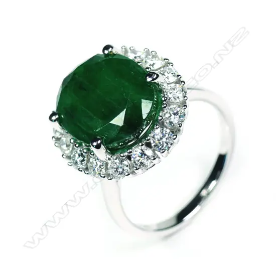 A 14ct white gold Zambian emerald and diamond halo ring