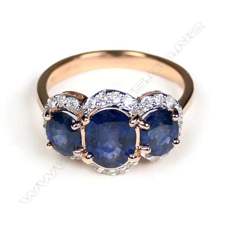 A 14ct rose gold sapphire and Diamond trilogy halo ring Image 1++