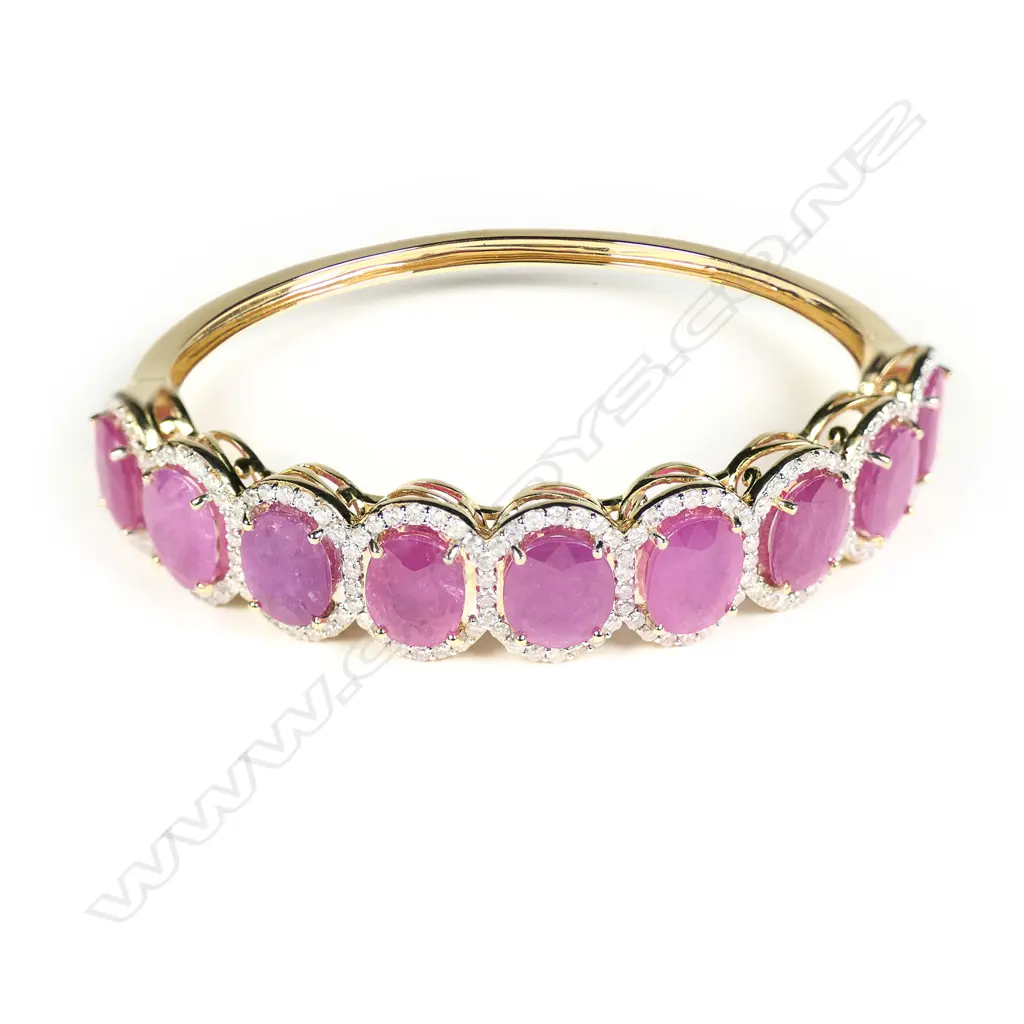 A 14ct gold ruby and diamond halo hinged bangle Image 1++