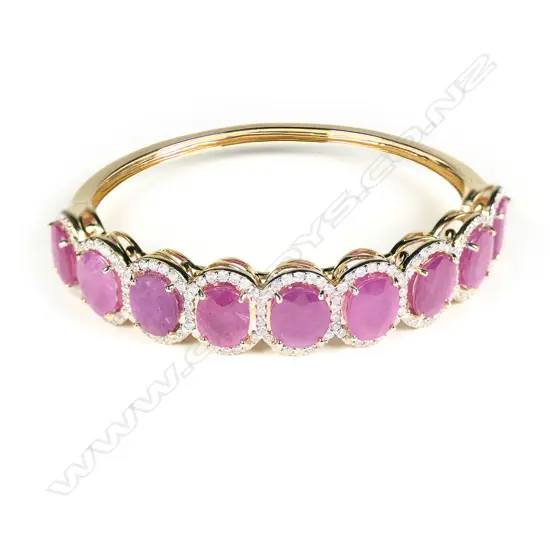 A 14ct gold ruby and diamond halo hinged bangle