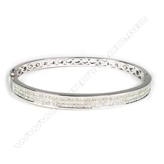 An 18ct white gold and multi diamond hinged bangle