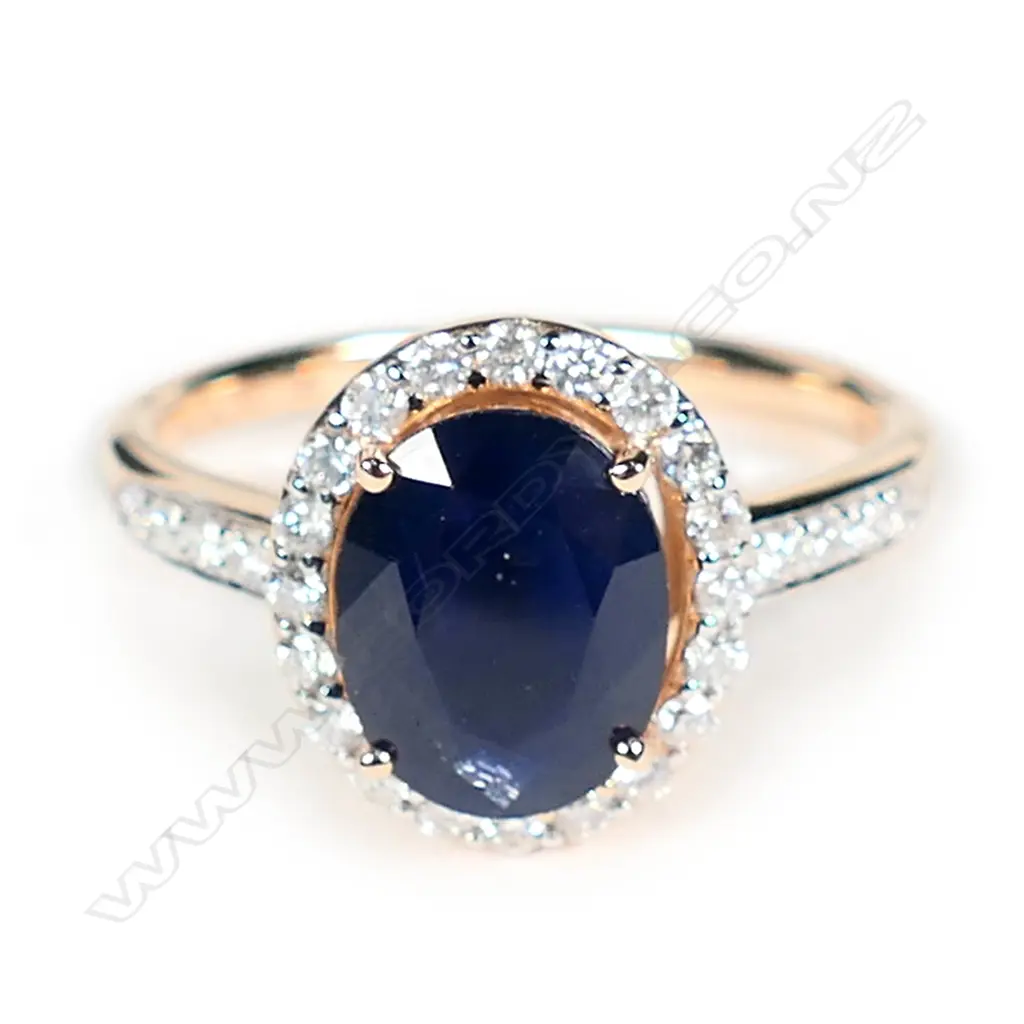 A 14ct rose gold blue sapphire and diamond halo ring Image 1++
