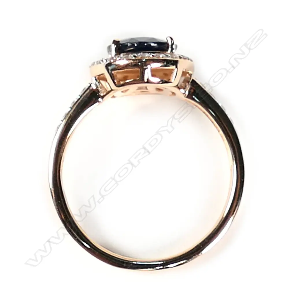 A 14ct rose gold blue sapphire and diamond halo ring Image 1++