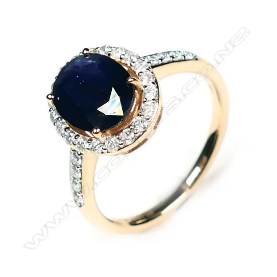 A 14ct rose gold blue sapphire and diamond halo ring