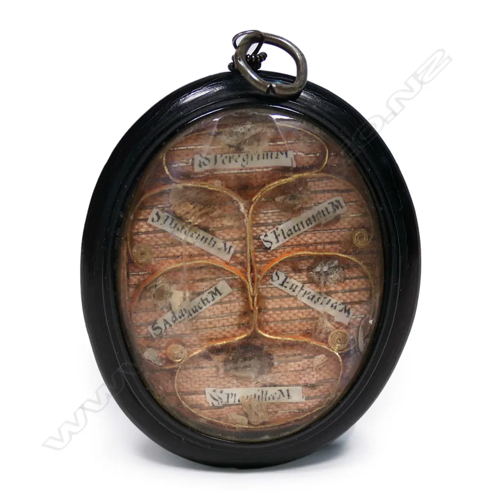 A portable reliquary in the form of a pendant, double sided with particular saints' minute body remains under faceted glass in a jet frame.  34 x 55mm. Image 1++