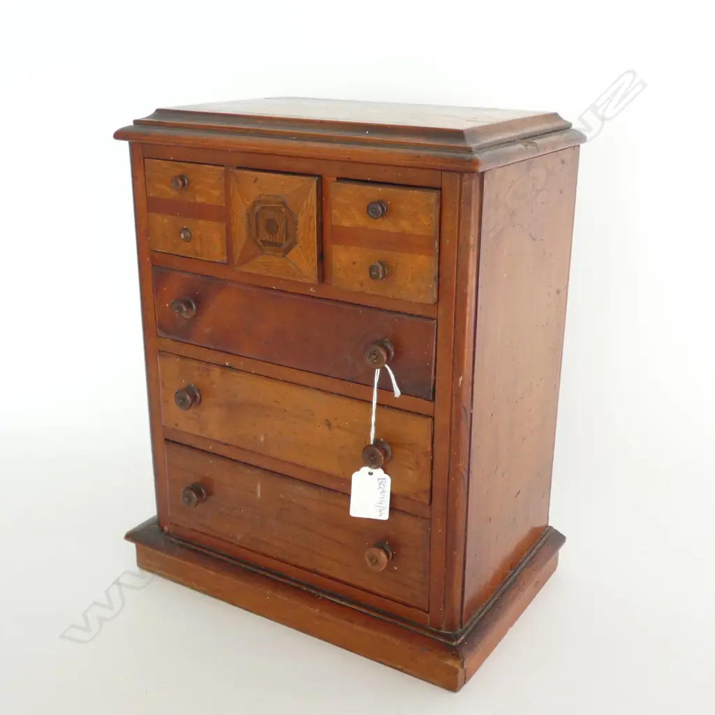 A colonial kauri apprentice chest, configured with four drawers and slots for paperwork at the base, mixed woods of kauri, totara and rewarewa, raised on plinth base. 440 x 270 x 500mm. Image 1++