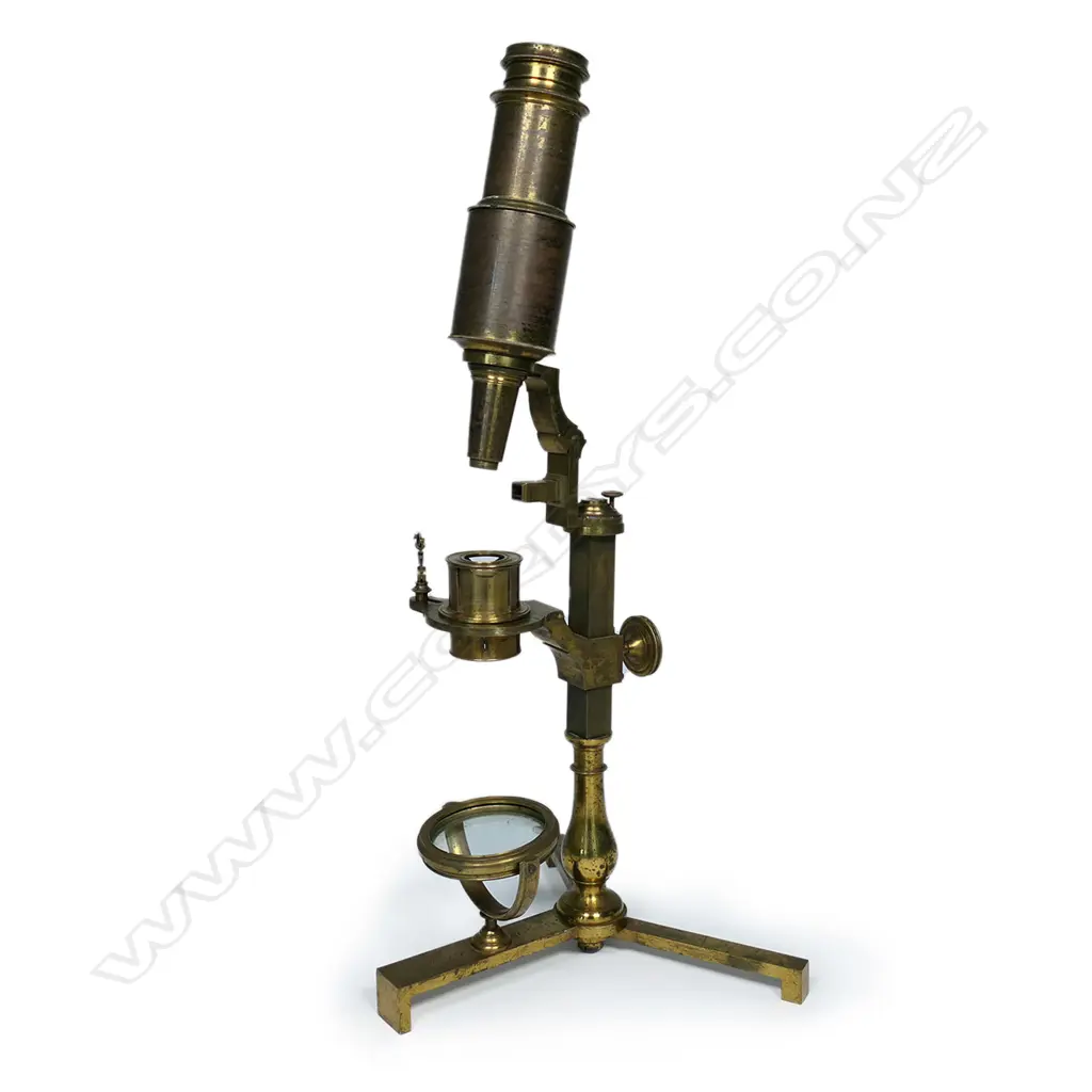 An early brass compound microscope by Benjamin Martin c.1775, the tube on a pivot hinge above a rack and pinion stage adjuster and baluster column from a folding tripod base, signed B. Martin, London. In original shagreen covered box with various additional lenses and parts. The case distressed. Image 1++