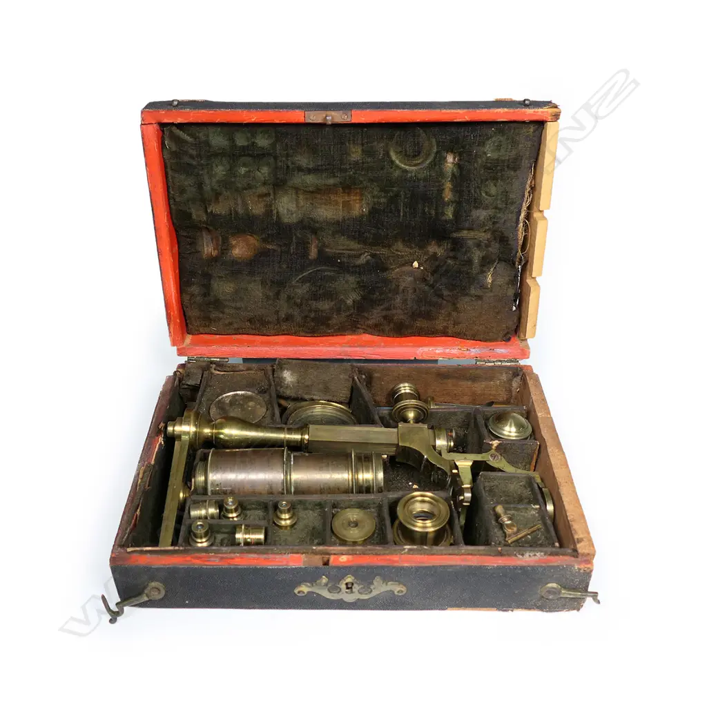 An early brass compound microscope by Benjamin Martin c.1775, the tube on a pivot hinge above a rack and pinion stage adjuster and baluster column from a folding tripod base, signed B. Martin, London. In original shagreen covered box with various additional lenses and parts. The case distressed. Image 1++