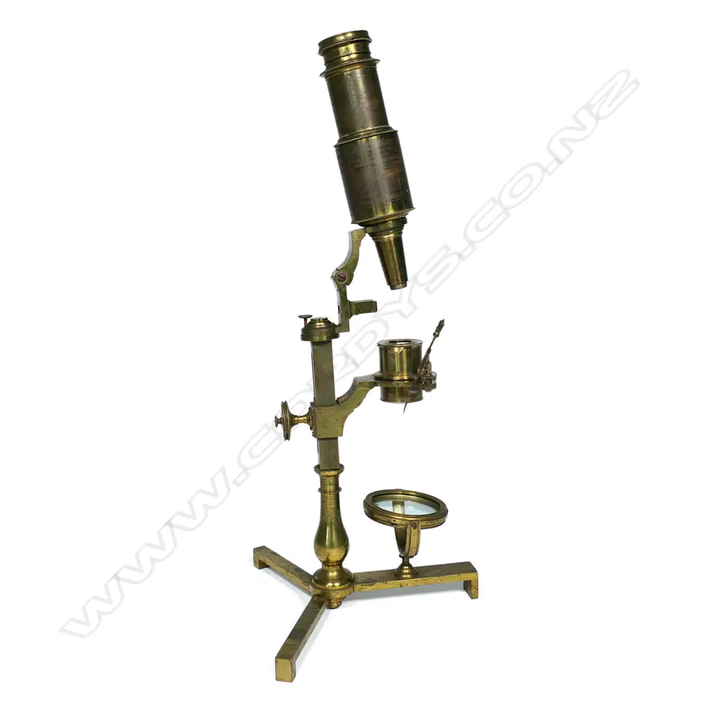 An early brass compound microscope by Benjamin Martin c.1775, the tube on a pivot hinge above a rack and pinion stage adjuster and baluster column from a folding tripod base, signed B. Martin, London. In original shagreen covered box with various additional lenses and parts. The case distressed. Image 1++