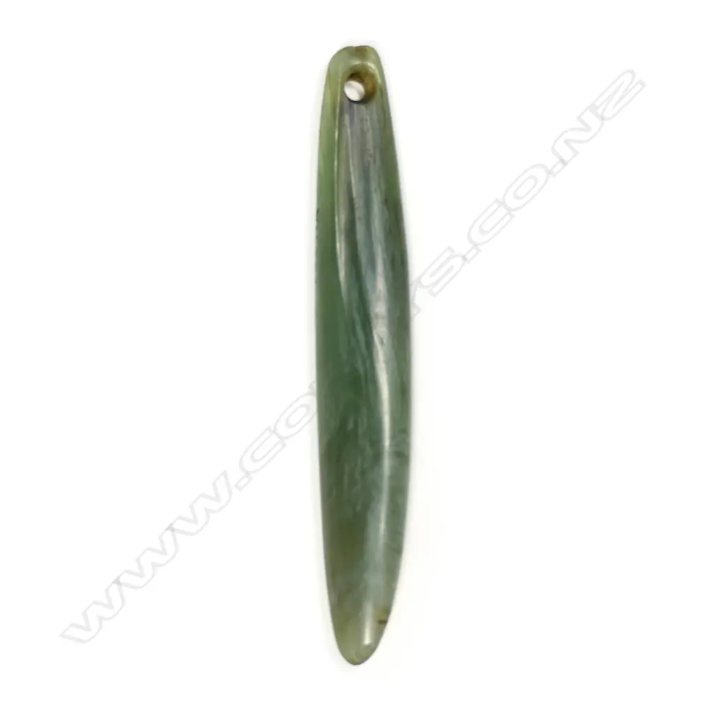 A Māori pre-European pounamu pendant, kuru type, light green tone, slightly curved form, with tapered suspension hole. Translucent with areas of white inclusion. Registered Y16354. Image 1++