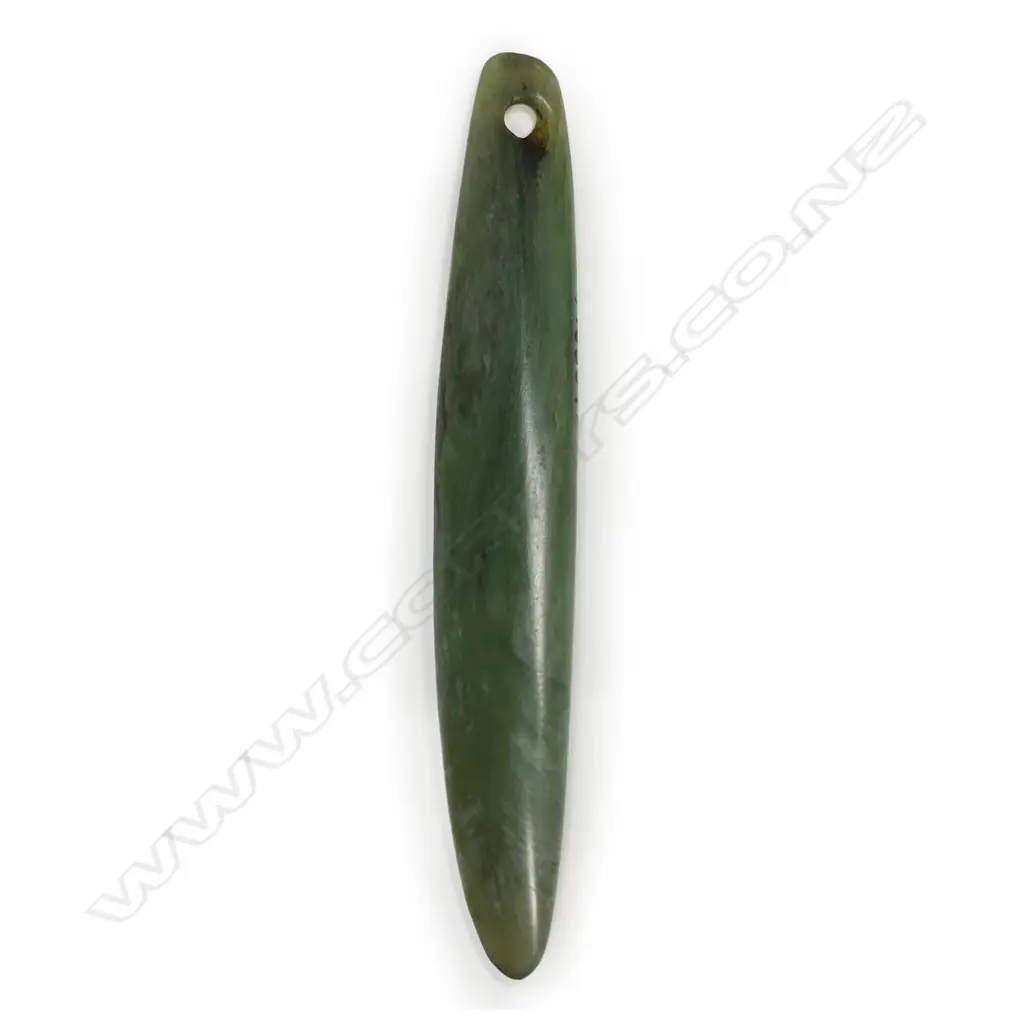 A Māori pre-European pounamu pendant, kuru type, light green tone, slightly curved form, with tapered suspension hole. Translucent with areas of white inclusion. Registered Y16354. Image 1++