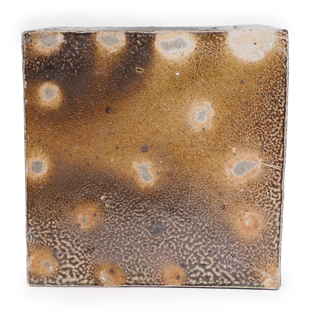 Warren Tippett large salt glazed square lidded box, rich dark brown with abstract pierced cut side panels with blue/green glaze. 210 x 210 x 220mm. Illustrated NZ Potter 1979, copy enclosed. Image 1++