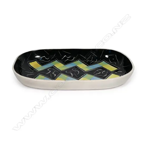 Warren Tippett rectangular dish, abstract blue and yellow zig-zag decoration on black ground with S-scroll and lineal decoration. Signed and dated '83. 317 x 195mm