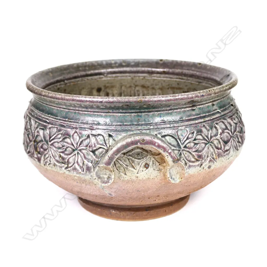 Warren Tippett decorated bowl, impressed band of repeating floral pattern, green and mauve glaze, two hooded handles. Dia.240mm. Labelled and dated '82. Provenance: Ex. the collection of Jacqui and Graeme Storm. Image 1++