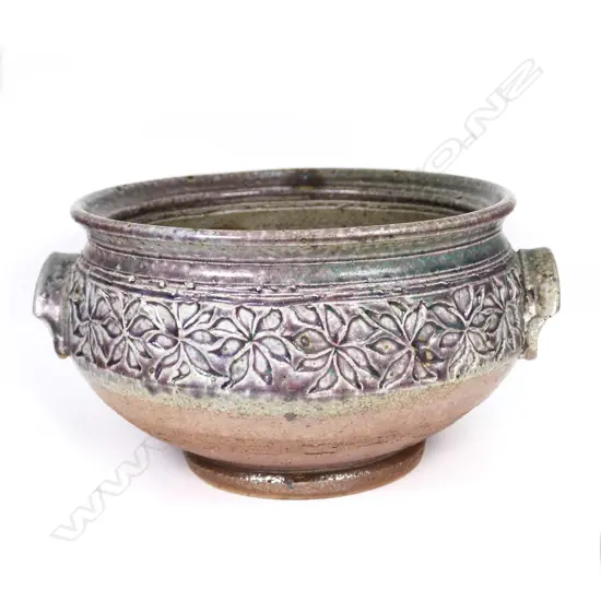 Warren Tippett decorated bowl, impressed band of repeating floral pattern, green and mauve glaze, two hooded handles. Dia.240mm. Labelled and dated '82. Provenance: Ex. the collection of Jacqui and Graeme Storm.
