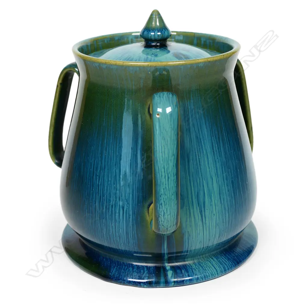 An Ashby Guild pottery lidded barrel, tapering shape on circular spreading foot, three elongated loop handles to the side. Streaked tonal blue green glaze. Impressed stamp. H.170mm Image 1++