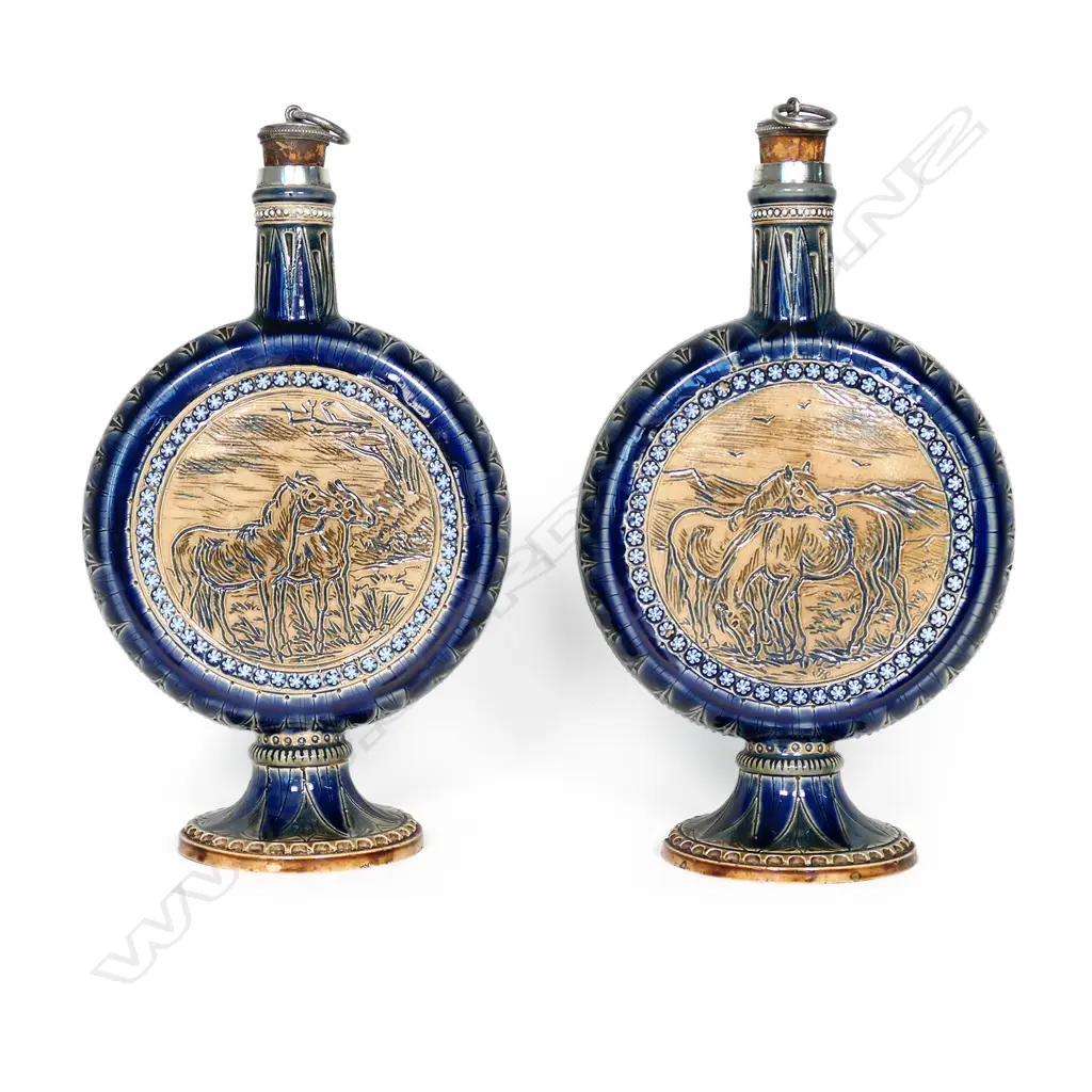 A rare pair of Doulton Lambeth flasks decorated by Hannah Barlow, the disc bodies incised sgrafitto to either side with ponies and horses, stags and hinds. The flasks raised on circular spreading bases (two chips to one and small flake to other) and with short cylindrical necks with silver mounts and ring caps to cork stoppers.  Impressed factory mark and date 1876 along with monograms for Barlow and assisting artists Emily E. Stomer and Emma Martin. Silver hallmarked for London 1876 by Jane Brownett. H.255mm. Image 1++