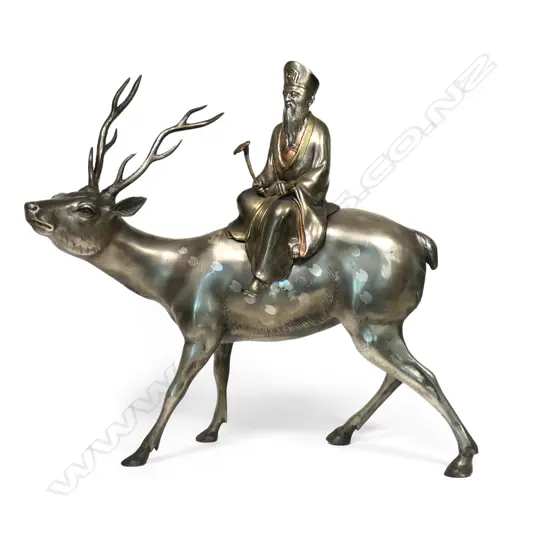 A vintage Chinese gilded bronze of a sage upon a deer, the sage (Shou Lao) with ruji sceptre and scroll, the stag with heart form spotted highlights. Repair to one antler. H.565. L.550mm.