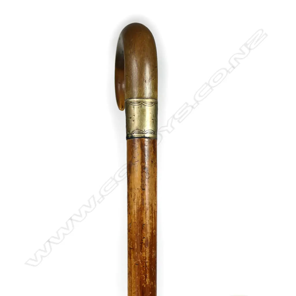 A c1900 horn handled walking stick, the Malacca cane tapered shaft with engraved silver plate ferrule and tapered curved fibrous horn handle. L.855mm. Image 1++
