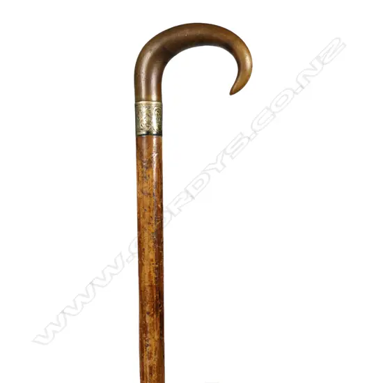 A c1900 horn handled walking stick, the Malacca cane tapered shaft with engraved silver plate ferrule and tapered curved fibrous horn handle. L.855mm.