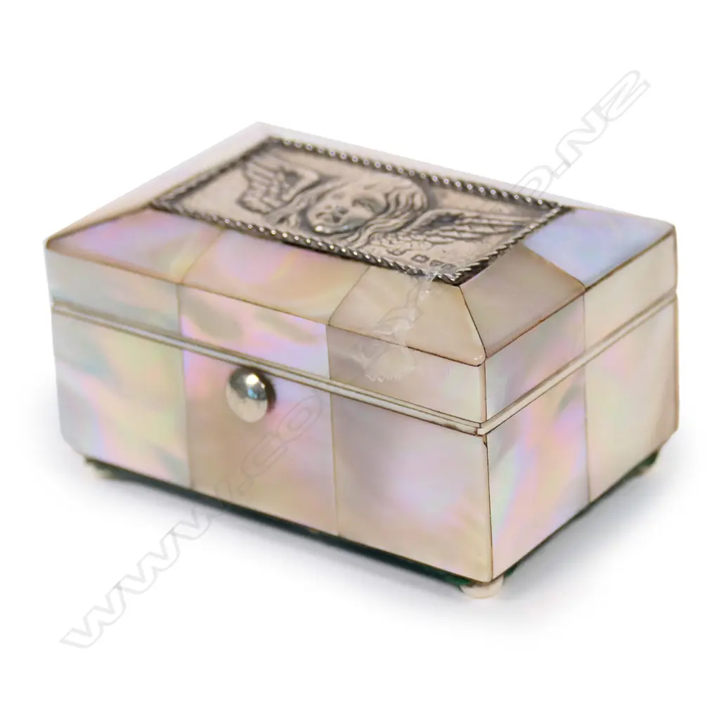 An Edwardian mother-of-pearl and silver jewel casket, panelled body, the silver lid embossed with a Reynolds angel. Silk and velvet lined two ring interior. Compressed ball feet. Chester 1905. 73 x 46 x 40mm. Image 1++