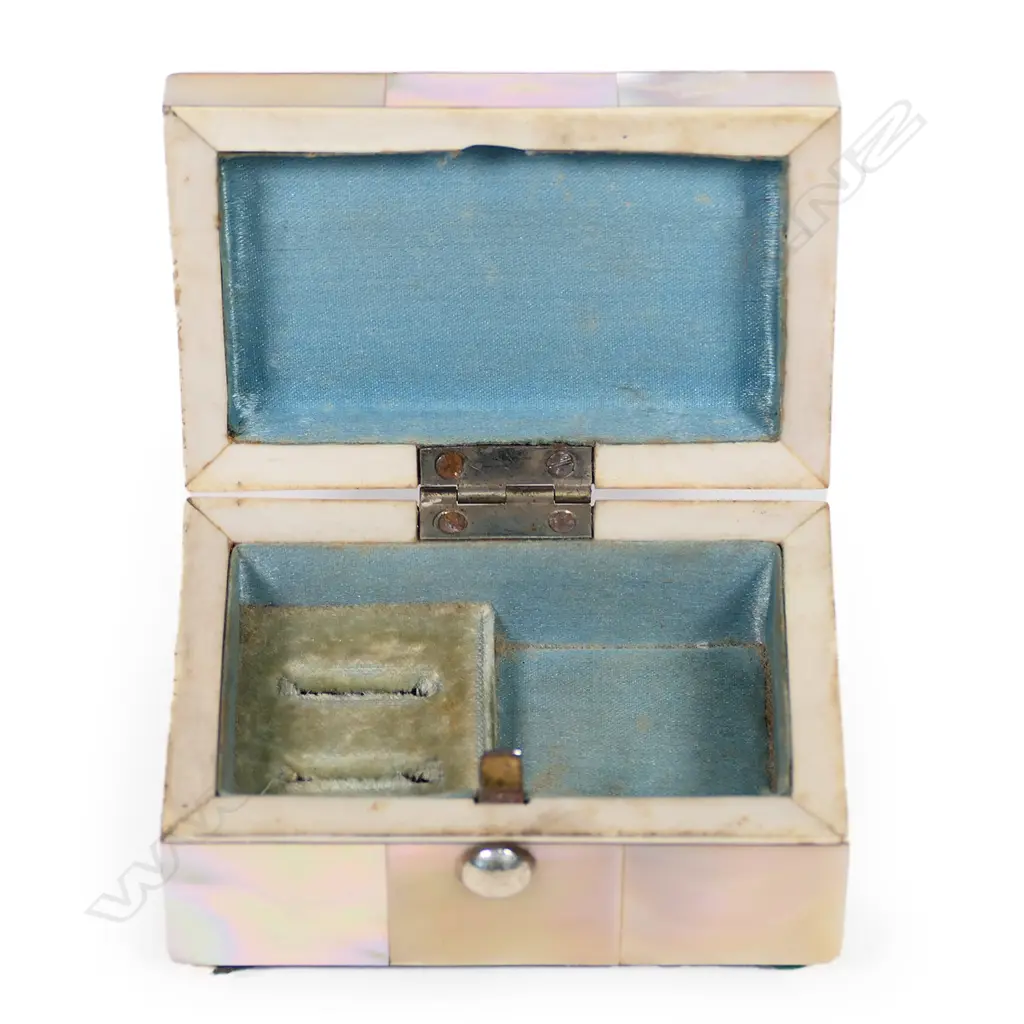 An Edwardian mother-of-pearl and silver jewel casket, panelled body, the silver lid embossed with a Reynolds angel. Silk and velvet lined two ring interior. Compressed ball feet. Chester 1905. 73 x 46 x 40mm. Image 1++