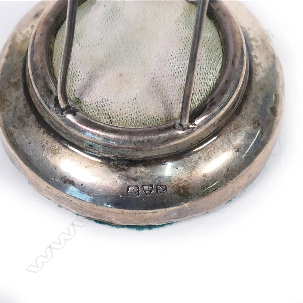 An Edwardian silver hat pin cushion stand, the top with the portrait bust of a maiden in profile. Chester 1908. H.74mm. Image 1++