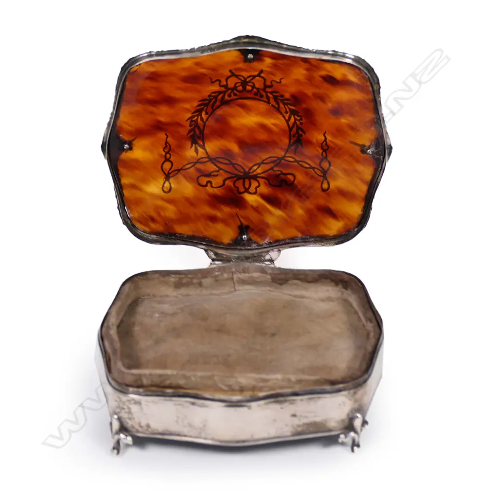 An Edwardian silver and tortoiseshell jewel box, in the French style, the top inlaid with silver pique work, raised on four scroll legs. Birmingham 1909. 100 x 85 x 40mm. Image 1++
