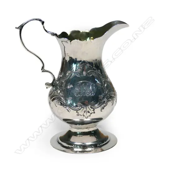 A Geo. III silver baluster cream jug, with serpentine rim, acanthus capped double scroll handle, foliate engraved body, gilt washed interior, raised on circular foot. London 1765 by Wm. Kinman (Grimwades mark 3210). H.105mm. 70gm