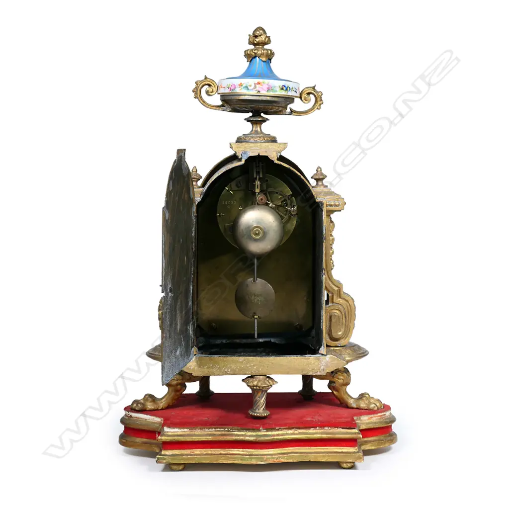 A French 19thC gilt metal and porcelain cased clock, the hand painted face and dial with figures, butterflies and flowers reserved on a bleu celeste ground, surmounted by an urn of conforming decoration. The bell striking 8-day movement stamped 'Japy Freres & Cie'. H.445mm on giltwood plinth. Provenance: The estate collection of Prof. G. Dawson. Image 1++