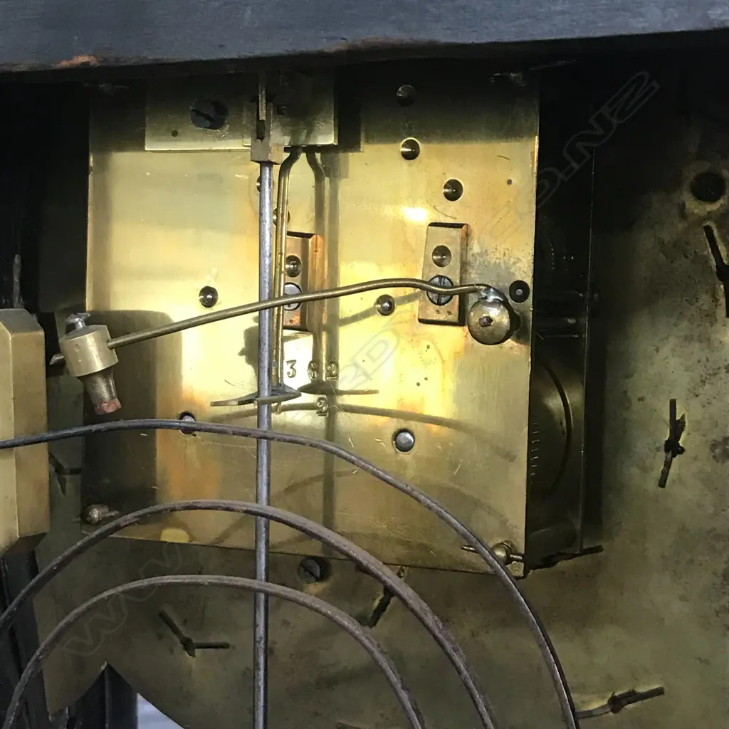 A Louis XVI-style mantel clock, the shaped case inlaid with cut brass Boulle work on black lacquered ground and heavily tarnished rococo ormolu mounts, surmounted by a pagoda top crowned by a standing heraldic angel figure. The cast dial with white enamel hour cartouches with blue Roman numerals, gong striking movement, sunburst pendulum above a sloping checkered floor, behind a glazed door mounted with a floral adorned putti. H.640mm. Image 1++