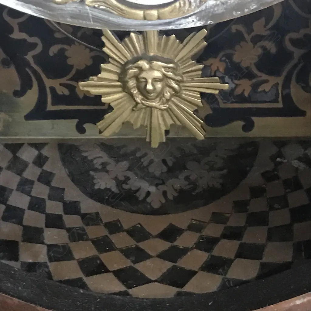 A Louis XVI-style mantel clock, the shaped case inlaid with cut brass Boulle work on black lacquered ground and heavily tarnished rococo ormolu mounts, surmounted by a pagoda top crowned by a standing heraldic angel figure. The cast dial with white enamel hour cartouches with blue Roman numerals, gong striking movement, sunburst pendulum above a sloping checkered floor, behind a glazed door mounted with a floral adorned putti. H.640mm. Image 1++